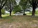 Charming home nestled among mature trees, featuring a well-manicured lawn and a wooden front ramp at 135 Hendren Ln, Hiddenite, NC 28636