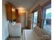Bright laundry area with washer, dryer, cabinets, and an exterior access door at 135 Hendren Ln, Hiddenite, NC 28636