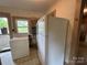 This laundry room features a washer, dryer, refrigerator, and a window for natural lighting at 135 Hendren Ln, Hiddenite, NC 28636