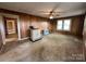 A cozy living room with wood paneling, carpet and a wood burning stove ready for your design ideas at 135 Hendren Ln, Hiddenite, NC 28636