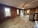 Bright living room showcasing wood paneling, a ceiling fan, and multiple windows at 135 Hendren Ln, Hiddenite, NC 28636
