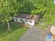 Aerial view of the home with a well-maintained lawn, driveway, and pergola at 1420 Columbus St, Albemarle, NC 28001