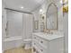 Bright bathroom featuring a white vanity, gold fixtures, and a shower-tub combo with white tile surround at 1420 Columbus St, Albemarle, NC 28001