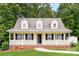 Charming yellow home featuring a welcoming front porch, black shutters and dormer windows at 1930 Manning Pl, Rock Hill, SC 29730
