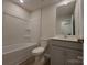 Clean bathroom with tub/shower combination, toilet, and vanity with grey cabinets at 2009 Vinyasa Ln # Sts-44, Charlotte, NC 28215