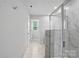 Bright bathroom with a marble tiled shower, white walls and floors, and a glass door at 2009 Vinyasa Ln # Sts-44, Charlotte, NC 28215