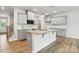 Open kitchen with gray cabinets, a granite island, stainless appliances, and light wood flooring at 2009 Vinyasa Ln # Sts-44, Charlotte, NC 28215