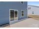 Backyard view of a blue house with a sliding glass door and a concrete patio at 2022 Mcdonald Dr, Stanfield, NC 28163