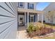 View of a home's front entrance with decorative plants, stone accents, and a covered porch at 2022 Mcdonald Dr, Stanfield, NC 28163