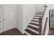 Staircase showcasing hardwood treads, white risers and handrail, and a view of the kitchen at 2022 Mcdonald Dr, Stanfield, NC 28163