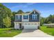 Charming two-story home featuring a two-car garage, well-manicured lawn, and a combination of gray and blue siding at 2106 Columbidae Ln, Gastonia, NC 28052