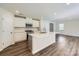 Modern kitchen with white cabinets, stainless steel appliances, large island, and luxury vinyl plank flooring at 2106 Columbidae Ln, Gastonia, NC 28052