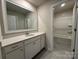 Well-lit bathroom with a single sink vanity, neutral color palette, and a separate toilet and shower area, maximizing space at 21110 Bank Fire Ln, Huntersville, NC 28078