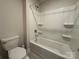 Clean bathroom with white fixtures, a tub/shower combo, and neutral tile at 21110 Bank Fire Ln, Huntersville, NC 28078