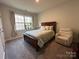 Well-lit bedroom features neutral walls, carpeted floors, a comfortable bed and a cozy armchair at 21110 Bank Fire Ln, Huntersville, NC 28078