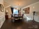 Elegant dining room with a chandelier, wainscoting, and dark wood floors at 21110 Bank Fire Ln, Huntersville, NC 28078