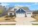 Charming two-story home with a three-car garage, blue siding accents, and a well-maintained yard at 21110 Bank Fire Ln, Huntersville, NC 28078