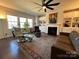 Cozy living room featuring a fireplace, built-in shelving, large windows, and comfortable seating at 21110 Bank Fire Ln, Huntersville, NC 28078