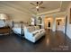 Relaxing primary bedroom with dark hardwood floors, tray ceiling, and a cozy sitting area, offering a peaceful retreat at 21110 Bank Fire Ln, Huntersville, NC 28078