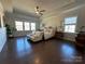 Spacious bedroom with tray ceilings, hardwood floors, a seating area, and plentiful natural light at 21110 Bank Fire Ln, Huntersville, NC 28078