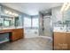 Bathroom featuring double vanities, garden tub, and a glass enclosed shower at 219 Pleasant Grove Ln, Mooresville, NC 28115