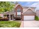 Attractive brick home with a well-maintained lawn, front porch, and two-car garage at 219 Pleasant Grove Ln, Mooresville, NC 28115