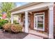 Inviting front porch with seating, flowers, and a charming entrance to the brick home at 219 Pleasant Grove Ln, Mooresville, NC 28115