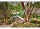 Community playground featuring multiple slides and play structures surrounded by trees and flowering bushes at 219 Pleasant Grove Ln, Mooresville, NC 28115