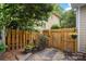 Fenced backyard entrance with a wooden gate, stone pathway, and potted flowers for added charm at 2306 Club Rd, Charlotte, NC 28205