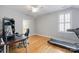 Bedroom featuring a desk, chair, treadmill, light hardwood floors, and white trim at 2306 Club Rd, Charlotte, NC 28205