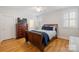 Comfortable bedroom featuring a wooden sleigh bed, a dresser with a TV, and shuttered windows at 2306 Club Rd, Charlotte, NC 28205