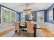 Elegant dining room with rustic chandelier, blue walls, and ample natural light at 2306 Club Rd, Charlotte, NC 28205