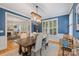 Elegant dining room with rustic chandelier, blue walls, and ample natural light at 2306 Club Rd, Charlotte, NC 28205