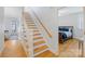 Hallway with hardwood floors, staircase, and an entrance to a bedroom with a sleigh bed at 2306 Club Rd, Charlotte, NC 28205