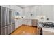 Well-lit kitchen showcasing stainless steel appliances, white cabinets, quartz countertops, and hardwood floors at 2306 Club Rd, Charlotte, NC 28205