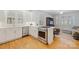 Bright kitchen featuring stainless steel appliances, white cabinets, hardwood floors, and an island cooktop at 2306 Club Rd, Charlotte, NC 28205