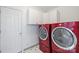 Bright laundry room featuring red washer and dryer units, and tiled flooring at 2306 Club Rd, Charlotte, NC 28205