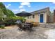 Private backyard patio featuring outdoor dining set, grill, beautiful flowers, and blue door access at 2306 Club Rd, Charlotte, NC 28205
