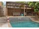 Relaxing pool area featuring a covered lounge space with seating and a charming mosaic waterfall at 2306 Club Rd, Charlotte, NC 28205
