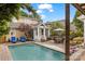 Landscaped backyard featuring a pool, dining, lounge chairs, and covered seating for outdoor enjoyment at 2306 Club Rd, Charlotte, NC 28205