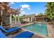 Stunning pool area with lounge chairs, covered seating, dining area, and meticulous landscaping at 2306 Club Rd, Charlotte, NC 28205