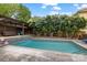 Inviting backyard pool featuring a tiled deck and a charming pergola covered seating area at 2306 Club Rd, Charlotte, NC 28205