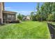 Spacious backyard featuring a well-maintained lawn, mature trees, play set, and covered porch for outdoor enjoyment at 2655 Stonewood Vw, Kannapolis, NC 28081