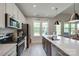 Kitchen with stainless steel appliances, kitchen island, and view of backyard through bright windows at 3029 Trace Meadow Ct, York, SC 29745