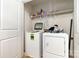 Convenient laundry room with a washing machine, dryer, overhead shelving, and a white door on the left at 3033 Green Apple Dr, Dallas, NC 28034