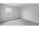 Neutral carpeted bedroom featuring window with blinds and natural light at 3535 Cramer Creek Dr, Gastonia, NC 28056