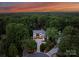 Aerial view of the home nestled among lush green trees in a picturesque neighborhood at sunset at 3933 Ayrshire Pl, Charlotte, NC 28210