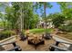 Backyard fire pit area with four black Adirondack chairs in a gravel-covered space with well maintained lawn at 3933 Ayrshire Pl, Charlotte, NC 28210