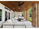 Spacious covered patio with ceiling fans, recessed lights, stone columns, and white cushioned outdoor seating arrangement at 3933 Ayrshire Pl, Charlotte, NC 28210