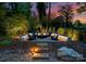 Beautifully lit backyard firepit area with stone pathway and four Adirondack chairs at 3933 Ayrshire Pl, Charlotte, NC 28210